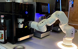 A closeup image of a BrewBots robotic barista making coffee